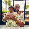 baby, child, man, smile, happy, indoor, window, greenery, table, hat, bowtie, patterned_shirt, beard, watch, hand, holding, portrait, people, family, casual