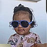 toddler, child, sunglasses, blue, hair, curly_hair, topknot, clothing, dog_pattern, cute, indoor, portrait, person, baby, face, expression, fashion, casual, young_child, smile