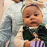 baby, bow, casual_clothing, child, communication, expression, face, glasses, headband, holding, indoor, inset, interaction, light, person, portrait, room, technology, video_call, woman