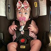 Millie joined the competition — help win amazing prizes! baby, infant, car_seat, pacifier, bow, child, safety_harness, cute, pink, wide_eyes, chubby_cheeks, seatbelt, face, person, indoor, clothing, headband, expression, sitting, closeup
