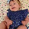 baby, infant, smile, blue_dress, headband, lying_down, patterned_blanket, happy, cute, child, small_hands, small_feet, face, person, indoors, colorful, floral, soft, portrait, young