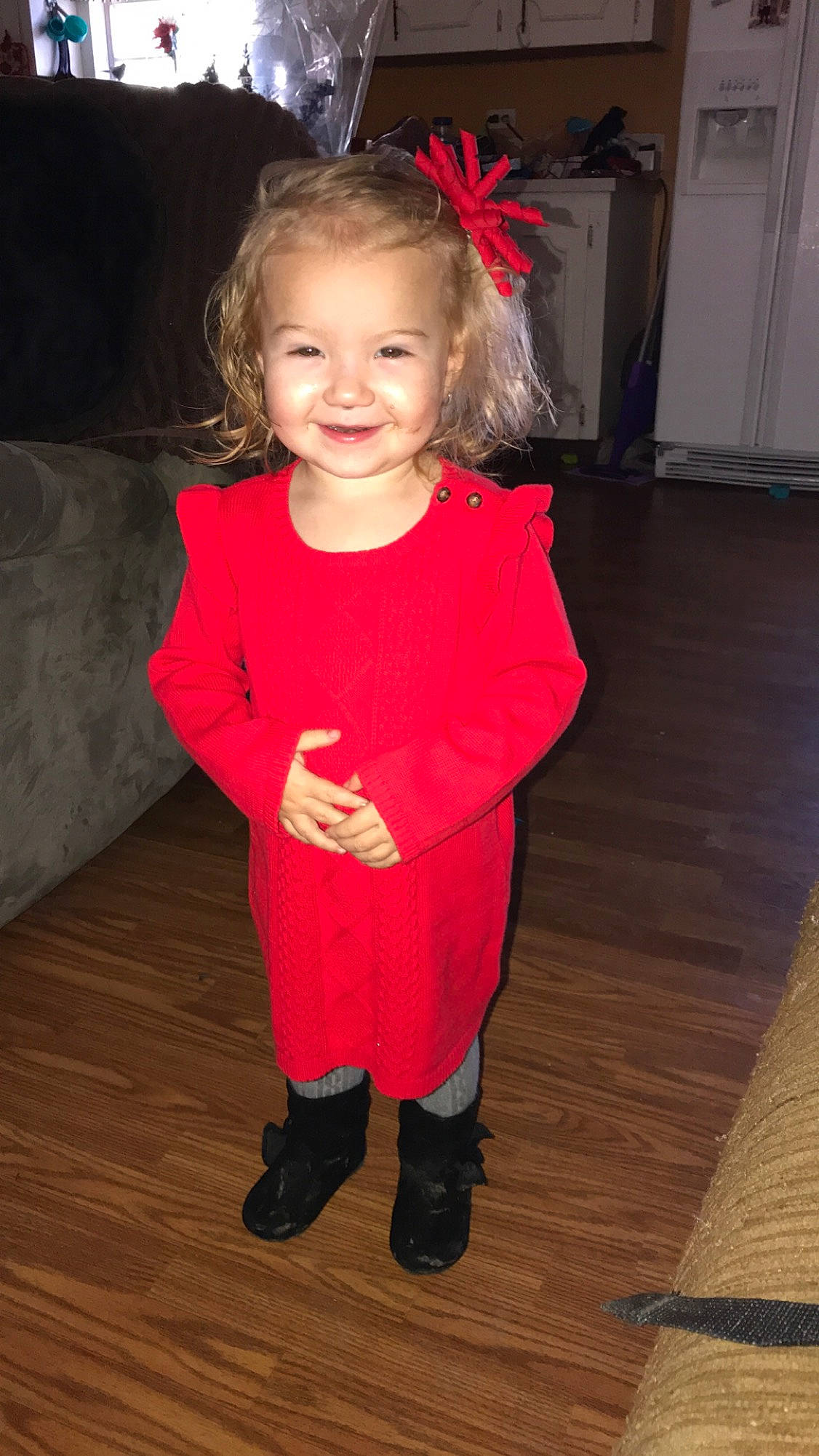 Rylie is registered to the contest to win money with this photo: child, clothing, costume, day, facial_expression, flooring, footwear, fun, girl, human_hair_color, joy, outerwear, person, product, red, shoulder, skin, smile, standing, textile