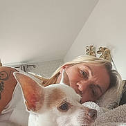 Iako participe au concours pour gagner de l'argent avec cette photo : dog, woman, pet, companion, portrait, cuddle, bed, blanket, indoors, home, cozy, white_dog, pointy_ears, chihuahua, human, face, blonde_hair, tattoo, soft_lighting, relaxed