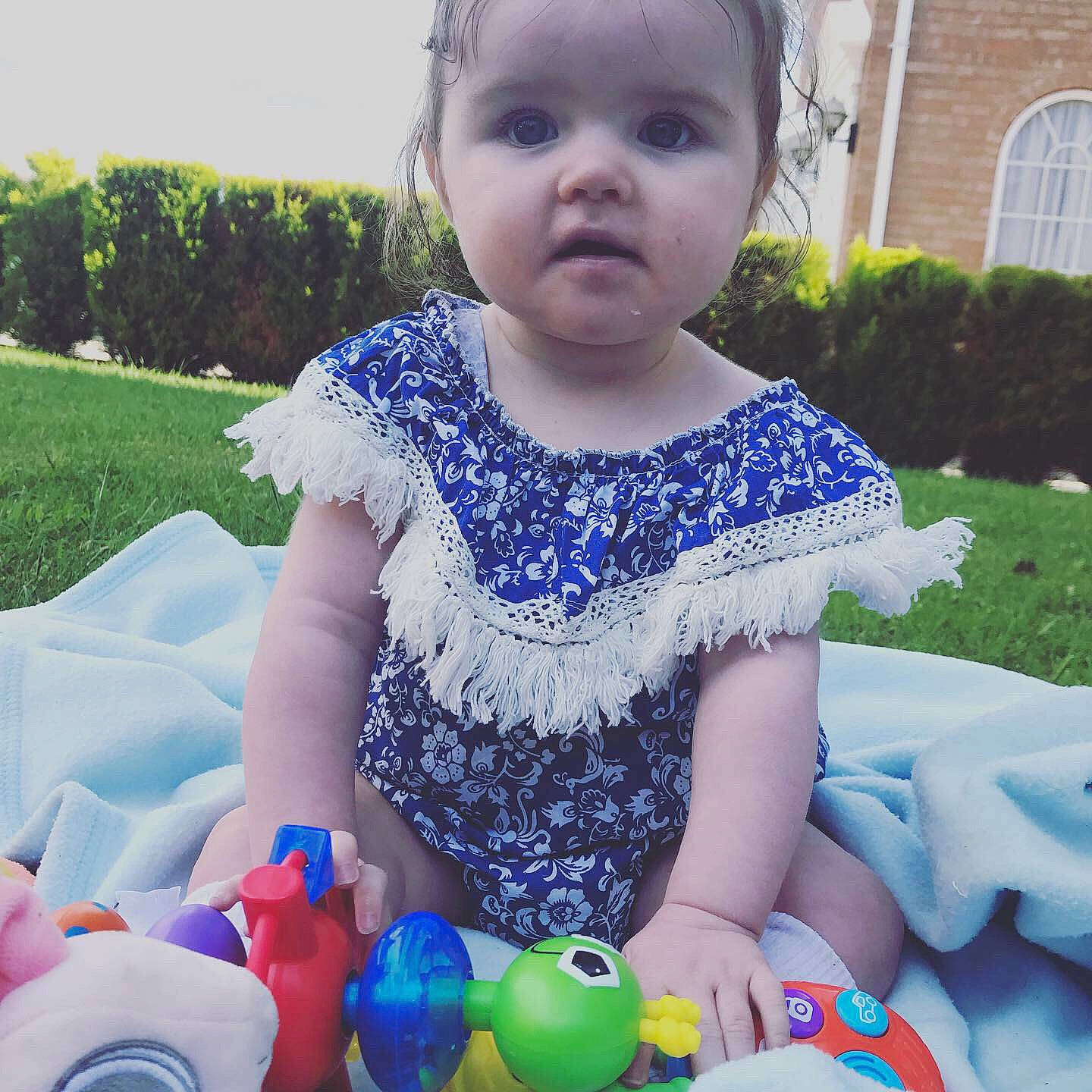 Hallie-rose is registered to the contest to win money with this photo: baby, baby_products, baby_toddler_clothing, blue, child, cool, dress, eye, face, grass, head, person, play, product, recreation, skin, smile, summer, toddler, vacation