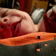 Austin is registered to the contest to win money with this photo: abdomen, baby, button, comfort, elbow, eyelash, finger, flesh, gesture, human_leg, mouth, nail, neck, nose, red, skin, sleeve, thumb, wood, wrist