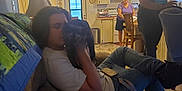 Mama is registered to the contest to win money with this photo: arm, black_hair, carnivore, comfort, companion_dog, conversation, dog, dog_breed, event, friendship, fun, human_leg, leisure, long_hair, mammal, room, sitting, t_shirt, thigh, youth