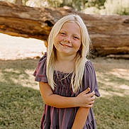 Rylie joined the competition — help win amazing prizes! child, girl, blonde_hair, smile, outdoor, grass, tree, log, sunlight, dress, portrait, nature, happy, person, young, casual, standing, daylight, cute, innocent