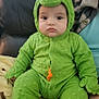 Liam joined the competition — help win amazing prizes! baby, infant, child, onesie, costume, dinosaur, green, hood, cute, portrait, sitting, couch, blanket, adult, face, eyes, expressionless, soft_texture, indoors, family