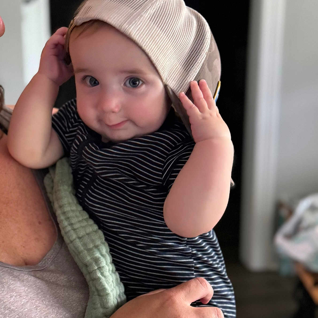 Maddux joined the competition — help win amazing prizes! adult, baby, cap, child, curious, cute, face, hand, headwear, holding, indoor, infant, person, portrait, short_sleeves, skin, smile, soft_light, striped_clothing, watch