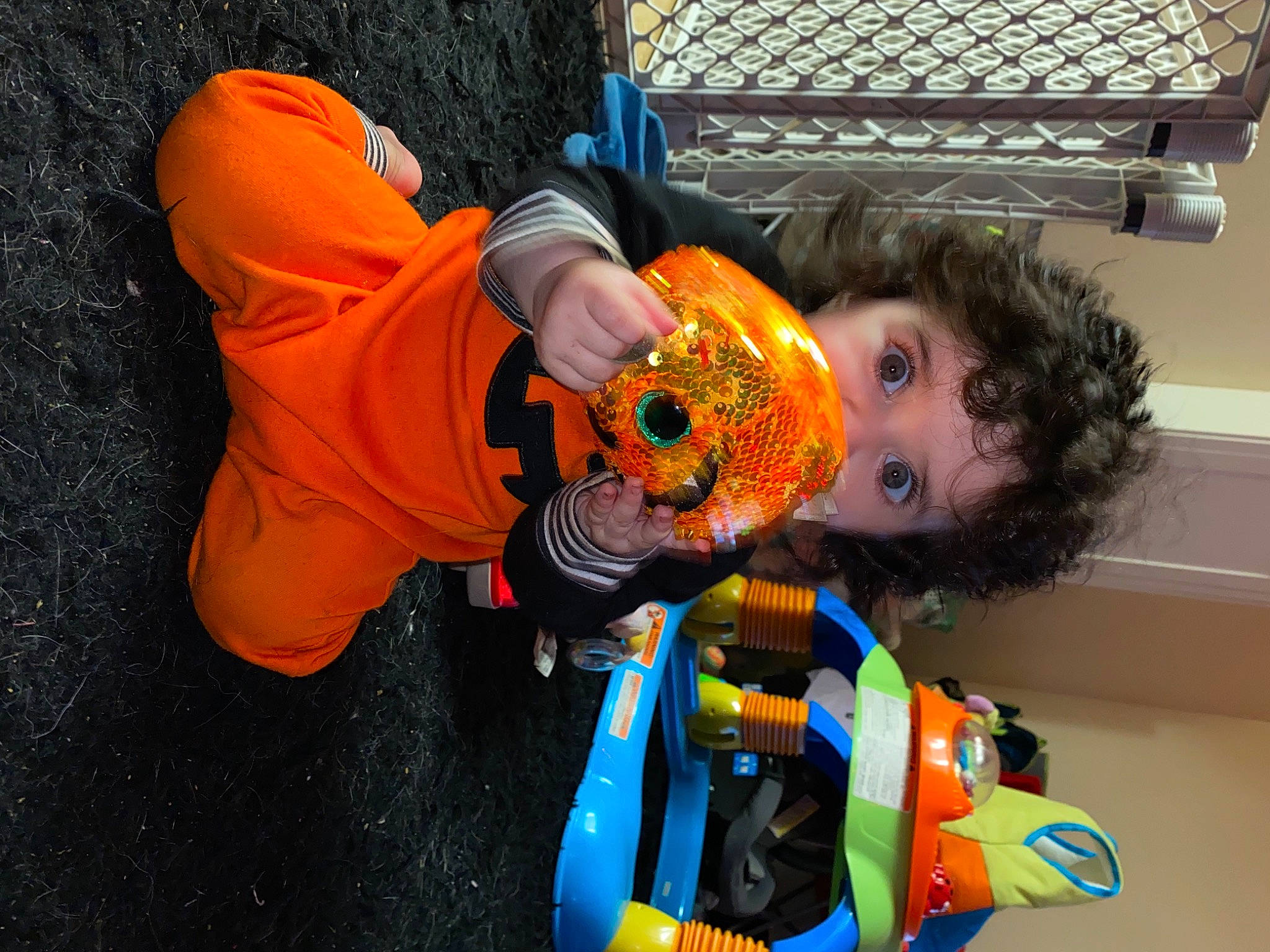 Kyla is registered to the contest to win money with this photo: baby_products, calabaza, child, costume, fun, glove, happy, leisure, orange, person, personal_protective_equipment, pumpkin, room, stuffed_toy, toddler, toy, trick_or_treat, vacation