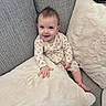 Kali joined the competition — help win amazing prizes! baby, child, smiling, couch, pillow, onesie, infant, happy, indoor, furniture, face, person, cute, cozy, soft, plush, sitting, casual, home, relaxed