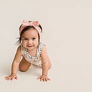 Anastasia is registered to the contest to win money with this photo: baby, child, crawling, smiling, headband, pink_bow, onesie, cute, infant, happy, portrait, minimalistic, studio, baby_girl, hands, face, eyes, hair, skin, indoor