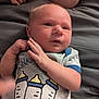 Nikolai joined the competition — help win amazing prizes! baby, newborn, infant, clothing, onesie, bottle_print, hand, face, skin, bed, blanket, blue_trim, cute, lying_down, young_child, expression, soft_light, indoors, person, infant_clothing