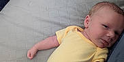 Ama joined the competition — help win amazing prizes! baby, infant, yellow_onesie, dinosaur_pants, playpen, soft_surface, sleepwear, child, newborn, cute, resting, indoor, portrait, small_hands, relaxed, face, skin, head, lying_down, clothing