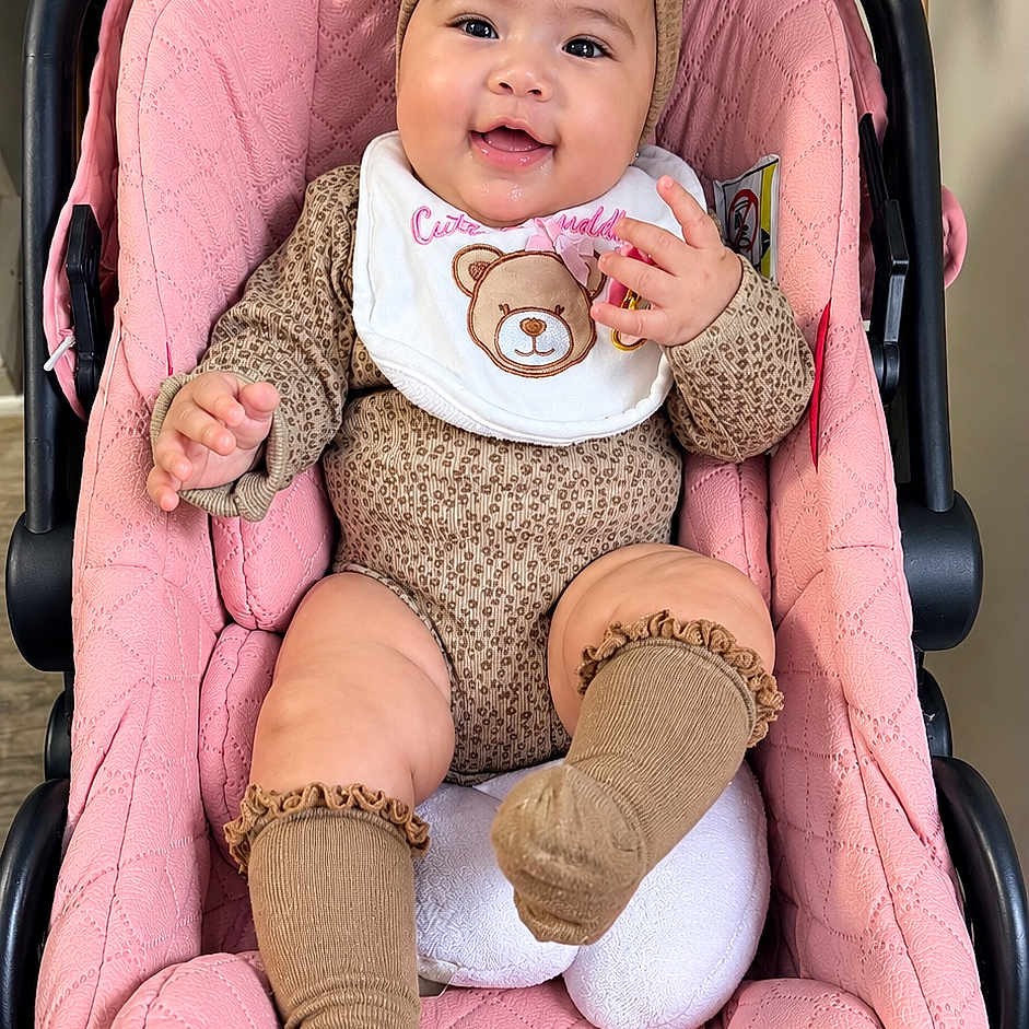 Beily joined the competition — help win amazing prizes! baby, child, infant, smiling, happy, portrait, stroller, pink, bow, headband, bib, teddy_bear, onesie, clothing, socks, seated, indoor, close_up, baby_carriage, cute