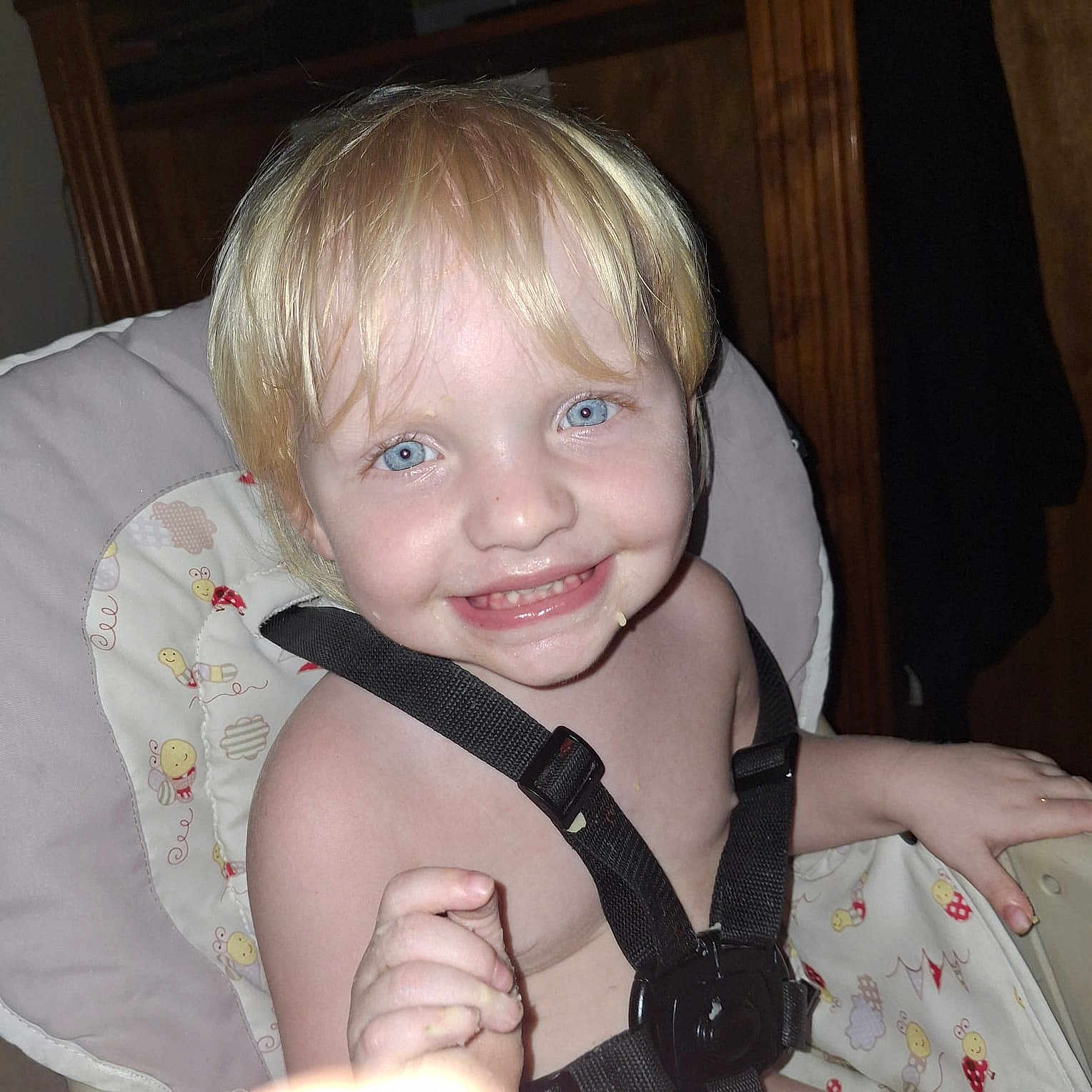 Hannah is registered to the contest to win money with this photo: child, toddler, smile, high_chair, harness, blonde_hair, blue_eyes, face, messy, food, indoor, person, baby, cute, happy, furniture, seat, seatbelt, closeup, skin