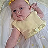 Hazel is registered to the contest to win money with this photo: baby, infant, yellow_headband, yellow_dress, bow, blue_eyes, cute, baby_girl, soft_fabric, white_tulle, floral_pattern, lying_down, closeup, portrait, child, face, skin, arm, cute_expression, indoors