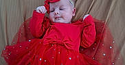 Hazel is registered to the contest to win money with this photo: baby, red_dress, bow, headband, tulle_skirt, stars, infant, cute, lying_down, bed, fabric, child, portrait, celebration, festive, adorable, clothing, smiling, baby_girl, soft_lighting