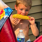 Jj joined the competition — help win amazing prizes! blond_hair, blue_eyes, boy, chair, child, corn, eating, face, food, hand, outdoor, person, shirtless, siding, skin, summer, sunlight, table, towel, water_bottle