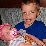 Jj joined the competition — help win amazing prizes! baby, boy, child, pacifier, headband, blue_shirt, pillow, bed, wooden_headboard, patterned_fabric, holding, smiling, infant, cute, indoors, family, portrait, young_children, sibling, happy