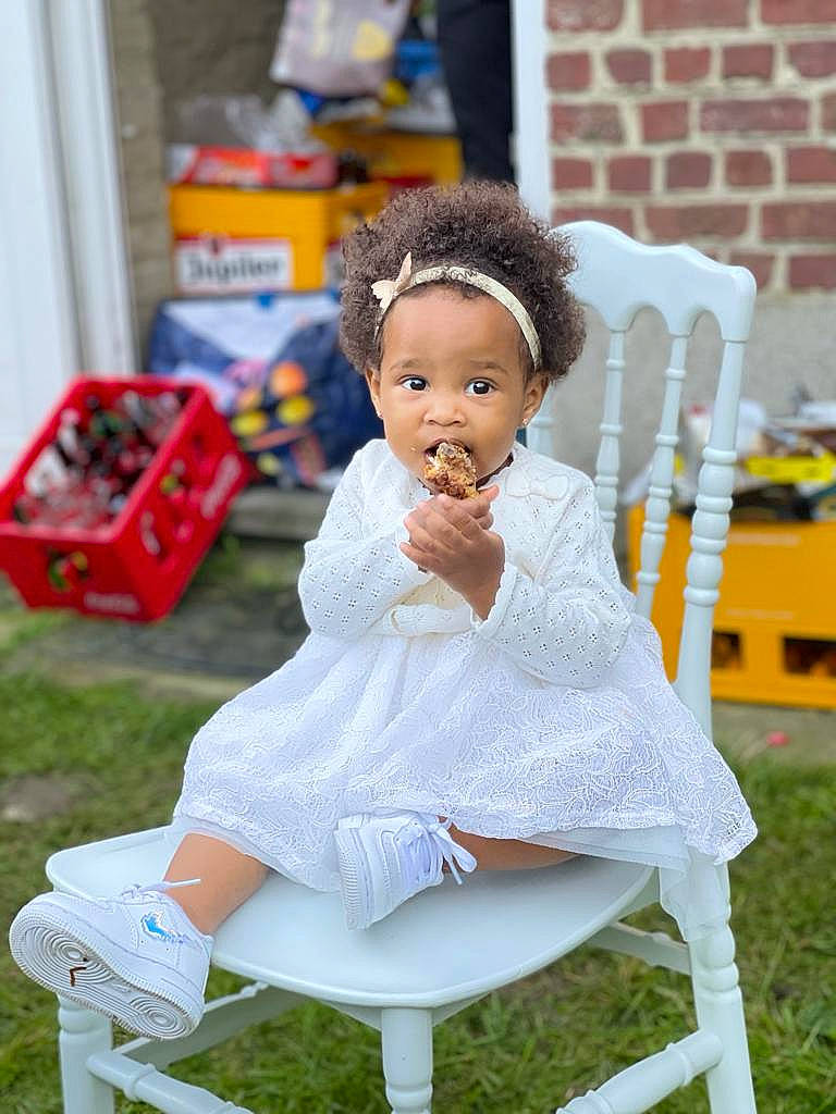 Inaya participe au concours pour gagner de l'argent avec cette photo : baby_toddler_clothing, child, dress, event, fun, grass, happy, human_leg, knee, leg, leisure, person, play, recreation, sitting, street_fashion, textile, toddler, toy, white