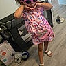 Layla Montoya is registered to the contest to win money with this photo: child, girl, dress, sunglasses, pink, playpen, toy, floor, indoor, purse, unicorn, sandals, playful, posing, hair_tie, colorful, room, slippers, stuffed_animal, wood_floor