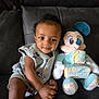 Amari is registered to the contest to win money with this photo: baby, child, plush_toy, mickey_mouse, blocks, months, sofa, couch, milestone, cute, smiling, clothing, indoor, portrait, young_child, sitting, toy, fabric, colorful, happy
