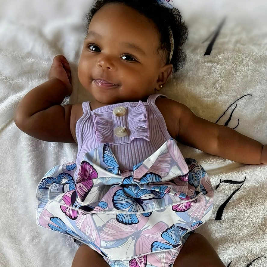 Addison is registered to the contest to win money with this photo: baby, bodypart, book, clothing, cushion, dress, face, finger, furniture, hand, happy, head, homedecor, newborn, person, photography, portrait, publication, shorts, smile