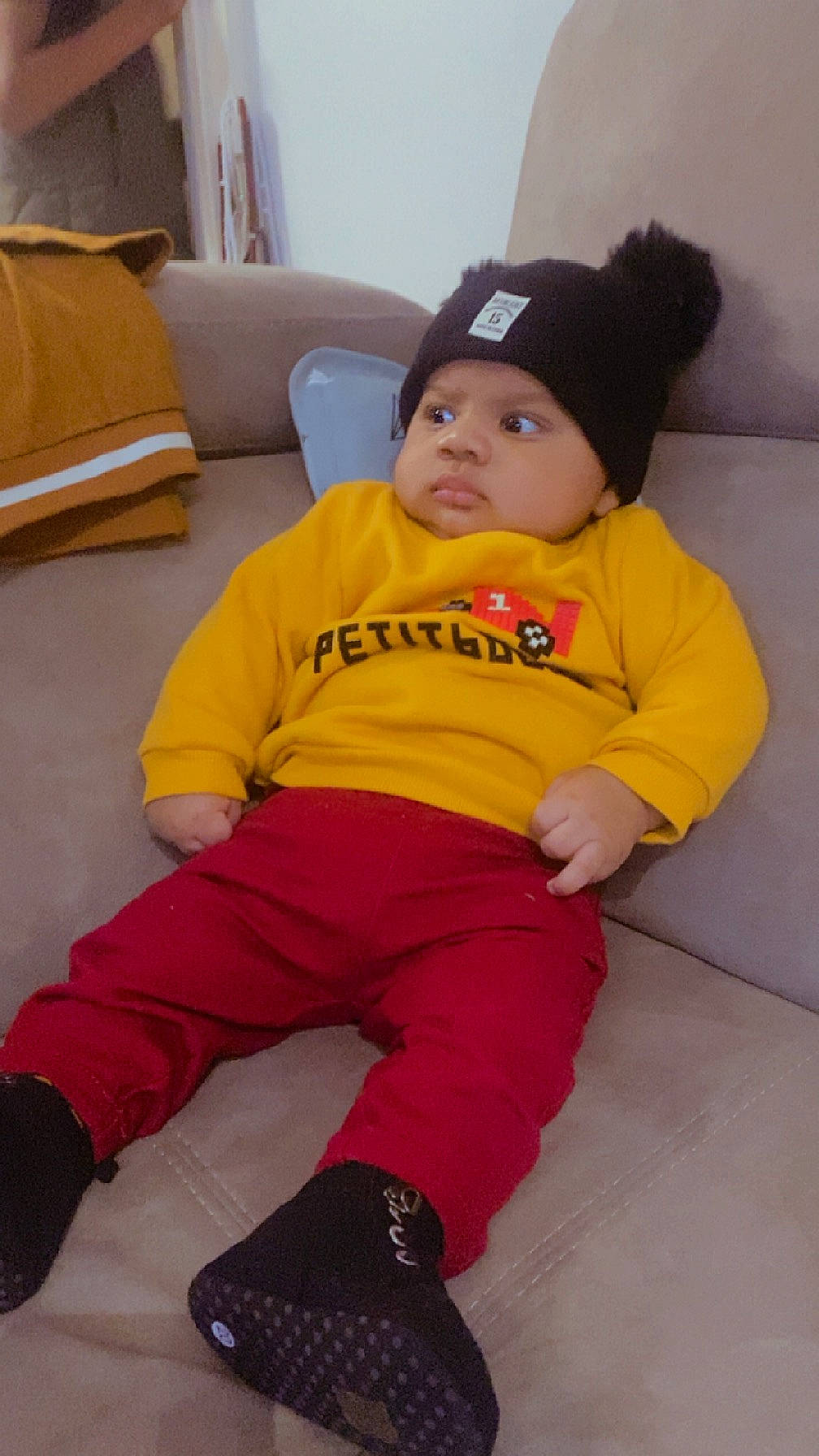 Sayon participe au concours pour gagner de l'argent avec cette photo : baby_toddler_clothing, cap, cheek, comfort, couch, floor, flooring, fun, headwear, human_body, human_leg, lap, leg, person, sitting, skin, sleeve, sock, t_shirt, textile