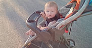 James joined the competition — help win amazing prizes! baby, casual, child, clothing, curious, daylight, expression, footwear, infant, outdoor, parked, pavement, person, seat, shadow, stroller, summer, sunlight, transport, wheel