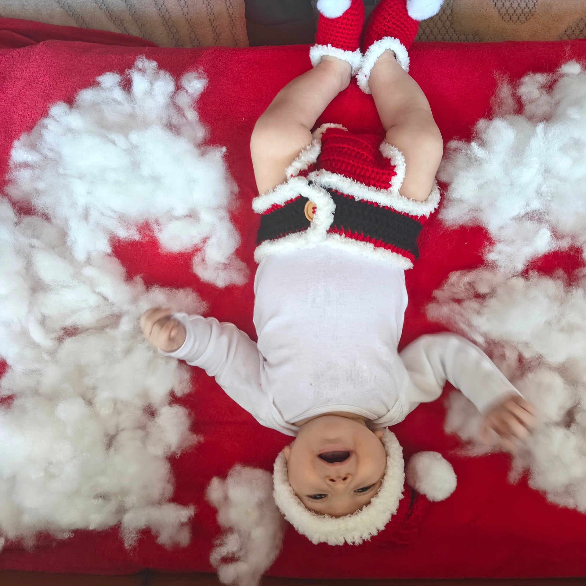 David joined the competition — help win amazing prizes! baby, infant, smiling, red_blanket, knitted_clothing, christmas_hat, holiday, festive, cotton, white_fluff, lying_down, cute, happy, indoor, child, seasonal, red_and_white, soft_texture, warm_clothing, celebration