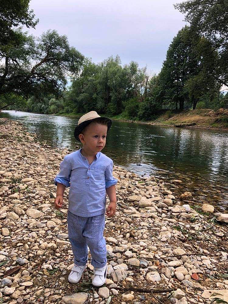 Samaël participe au concours pour gagner de l'argent avec cette photo : bank, child, grass, lacustrine_plain, lake, landscape, leisure, people_in_nature, person, pond, recreation, reservoir, sky, soil, sun_hat, toddler, tree, water, water_resources, watercourse