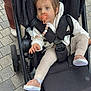 Ayline participe au concours pour gagner de l'argent avec cette photo : baby, pacifier, stroller, child, outdoor, pavement, pink_shoes, beige_leggings, black_stroller, person, seatbelt, toy_chain, curious, walking, footwear, casual_clothing, urban, small_child, cute, daylight