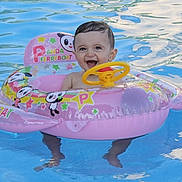 Yanis a rejoint le concours — aidez-le/la à gagner de superbes lots ! baby, child, pool, water, inflatable_boat, pink, panda, steering_wheel, smiling, happy, summer, outdoor, fun, toy, floating, cute, splash, vacation, swimming, playful