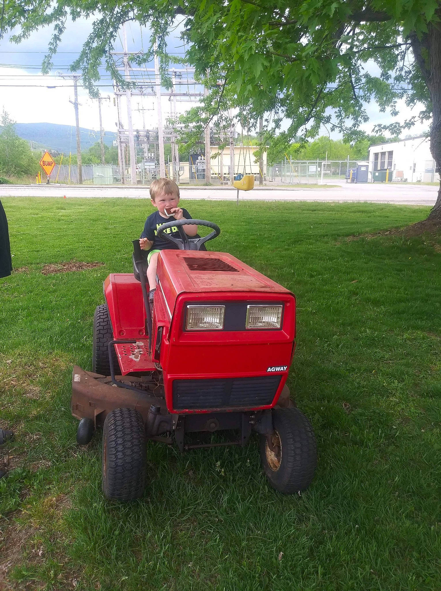 Louis is registered to the contest to win money with this photo: agricultural_machinery, car, fodder, grass, grassland, joy, land_vehicle, lawn, lawn_mower, outdoor_power_equipment, person, plant, riding_mower, tractor, vehicle