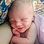 baby, newborn, infant, sleeping, smiling, face, head, hand, arm, skin, blanket, crib, patterned_fabric, close_up, portrait, cozy, peaceful, nursery, soft_lighting, cute