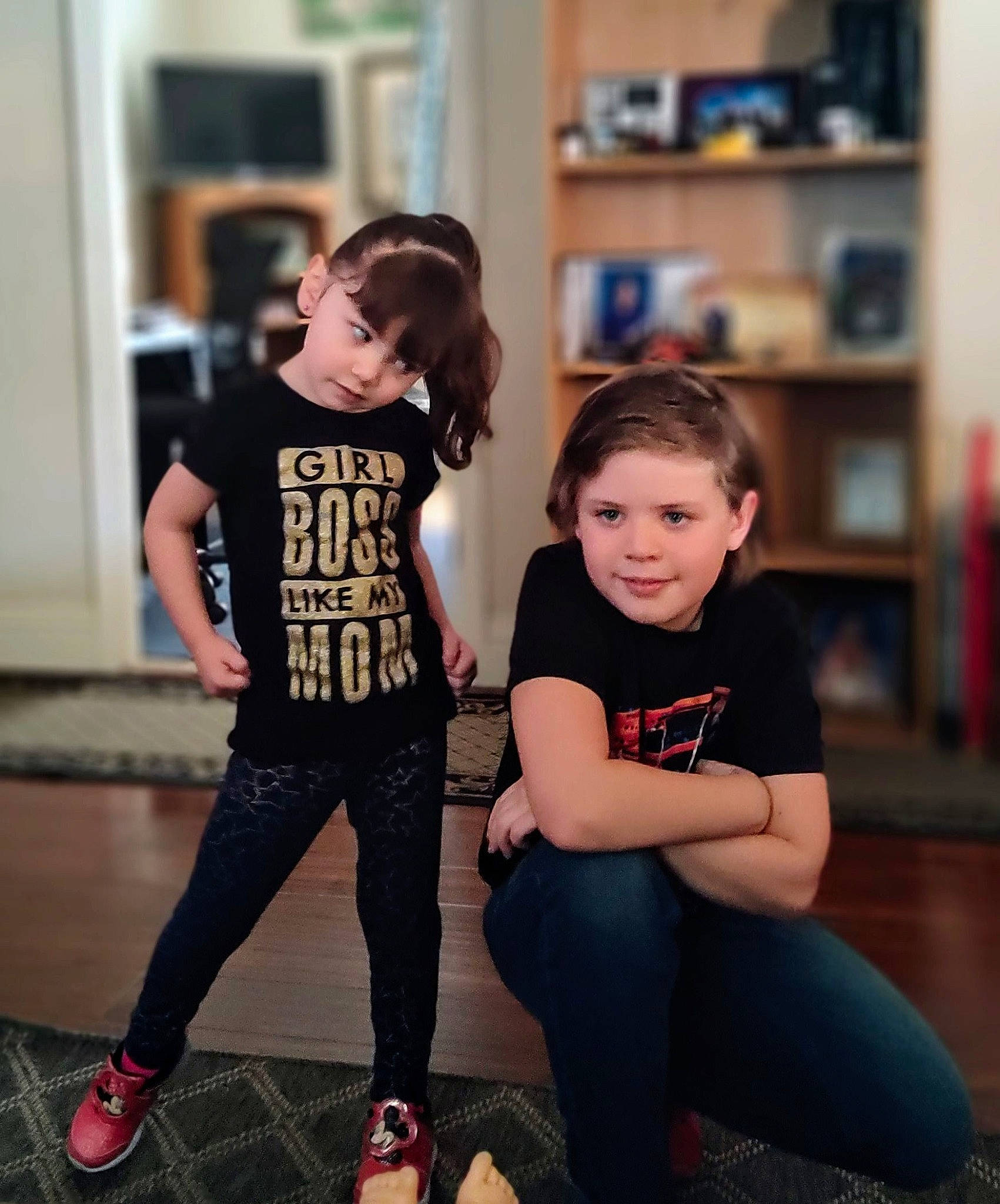 Abby joined the competition — help win amazing prizes! black, bookcase, cool, face, flash_photography, flooring, hairstyle, happy, jeans, joint, joy, knee, leg, person, shelf, shoe, shoulder, sleeve, standing, t_shirt