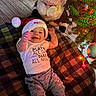 Giovanni is registered to the contest to win money with this photo: baby, child, santa_hat, plush_toy, christmas_tree, christmas_lights, blanket, floor, pajamas, festive, holiday, smiling, happy, indoors, toy, person, cute, infant, decorations, cozy
