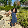 Aria joined the competition — help win amazing prizes! child, girl, curly_hair, polka_dot_dress, white_sandals, rock, outdoor, greenery, bushes, trees, sunny, blue_sky, playful, peace_sign, pout, nature, summer, portrait, person, fashion