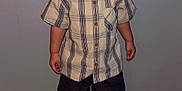 Xander is registered to the contest to win money with this photo: toddler, child, curly_hair, plaid_shirt, shorts, sneakers, indoor, carpet, wall, standing, portrait, person, cute, young, smiling, fashion, casual, feet, hands, expression