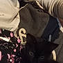 kitten, black_cat, pet, animal, feline, soft, fabric, clothing, pattern, floral, cute, indoors, closeup, cozy, dark, eyes, small, resting, comfort, warm