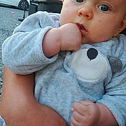 Kayston participe au concours pour gagner de l'argent avec cette photo : baby, child, hand, face, blue_eyes, pajamas, outdoor, person, holding, infant, cute, expression, soft_clothing, adult_hand, grip, portrait, casual, daylight, background, car