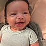 Makari is registered to the contest to win money with this photo: baby, smiling, infant, clothing, onesie, nike, happy, face, hair, skin, cute, portrait, child, young, person, laying, soft, fabric, indoors, closeup