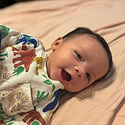 Makari joined the competition — help win amazing prizes! baby, infant, smile, happy, face, person, clothing, animal_print, bed, blanket, cute, lying_down, child, indoors, skin, head, eyes, mouth, cheeks, soft