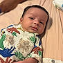 Makari is registered to the contest to win money with this photo: baby, infant, dinosaur_clothing, bed, soft_fabric, person, child, cute, lying_down, small_arm, patterned_outfit, skin, face, head, eyes, mouth, indoor, human, young_child, comfort