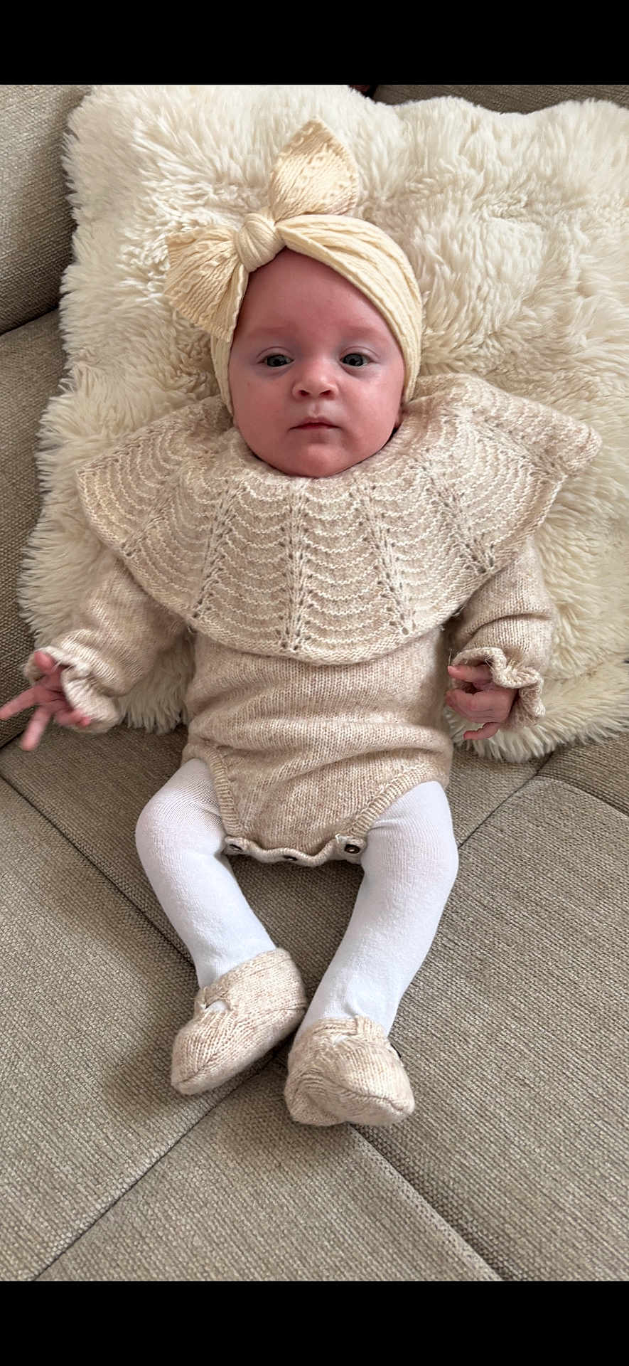 Héliana a rejoint le concours — aidez-le/la à gagner de superbes lots ! baby, infant, child, headband, bow, blanket, couch, knitwear, onesie, tights, booties, portrait, face, eyes, hands, feet, soft_texture, neutral_expression, cozy, indoors