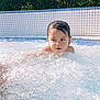 child, pool, water, bubbles, wet_hair, outdoor, sunlight, greenery, tiles, swimming, summer, splashing, garden, leisure, recreation, daytime, fun, person, young, relaxation