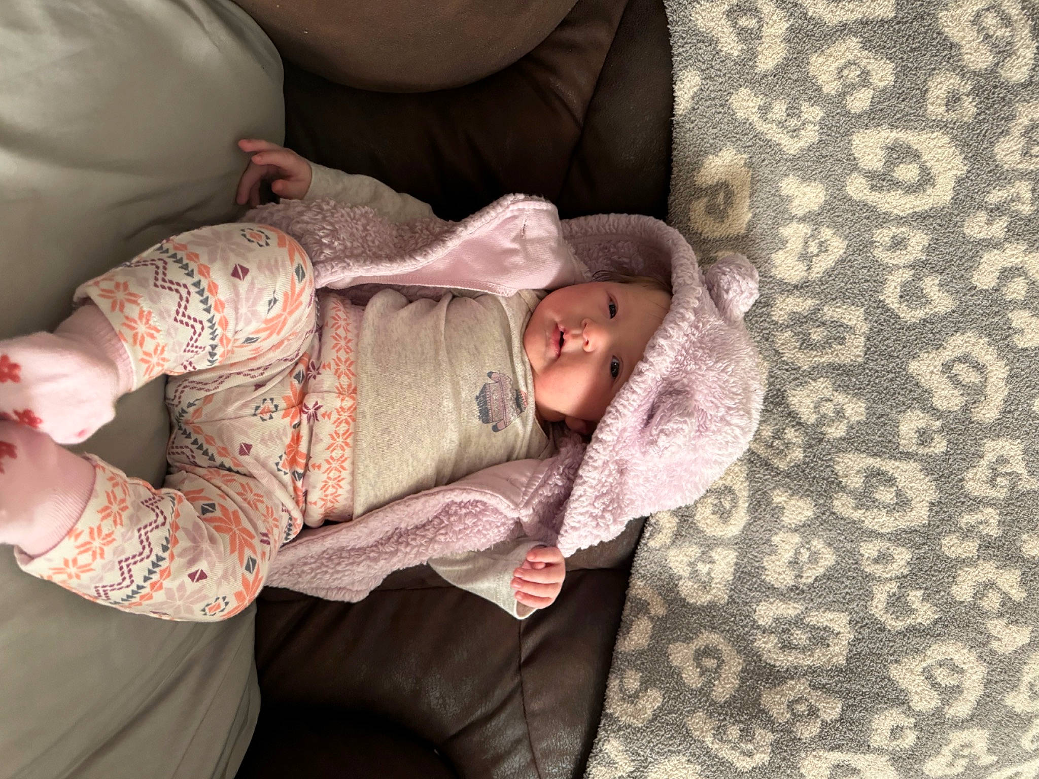 Hadley is registered to the contest to win money with this photo: baby, comfort, elbow, eye, facial_expression, finger, gesture, glasses, headwear, human_body, interaction, joint, mouth, person, pink, skin, sleeve, stomach, textile, thigh