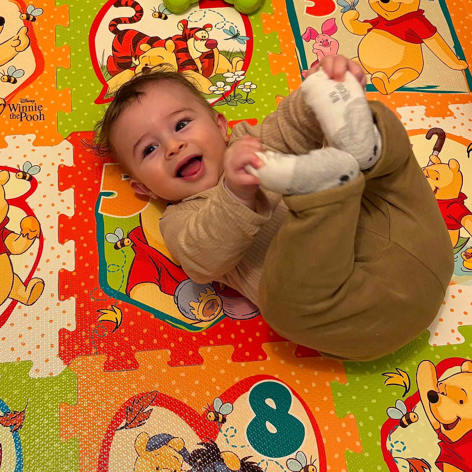 Nouaym a rejoint le concours — aidez-le/la à gagner de superbes lots ! baby, cartoon, child, clothing, colorful, cute, floor_mat, foot, hand, happy, indoor, infant, person, play_mat, playful, smiling, sock, toddler, toy, winnie_the_pooh