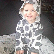Kami joined the competition — help win amazing prizes! toddler, child, smiling, cow_costume, onesie, hood, ears, horns, happy, sitting, indoor, person, legs, clothing, cute, baby, cozy, fun, playful, joyful